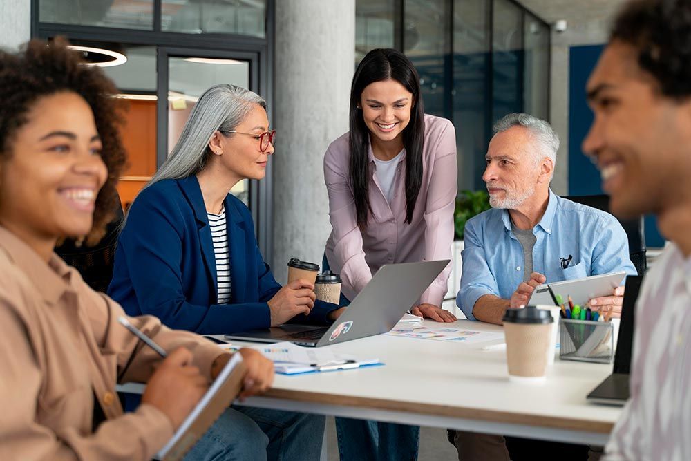 A group of people are sitting around a table having a meeting.
