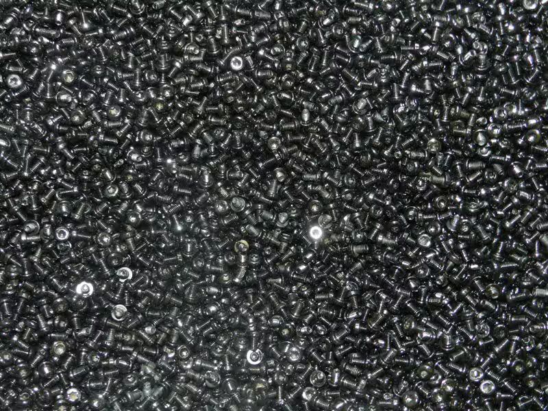 Primo piano di un mucchio di perline nere lucide simili a pellet sparse su una superficie