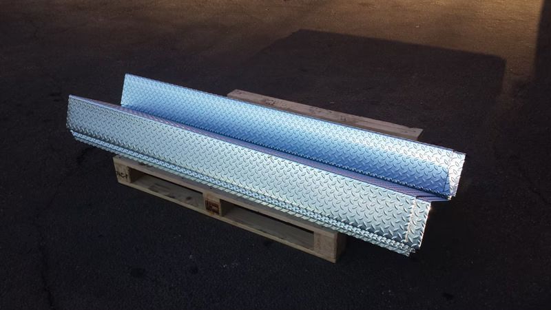 Panchina blu metallizzata e argento con lati perforati su sfondo scuro