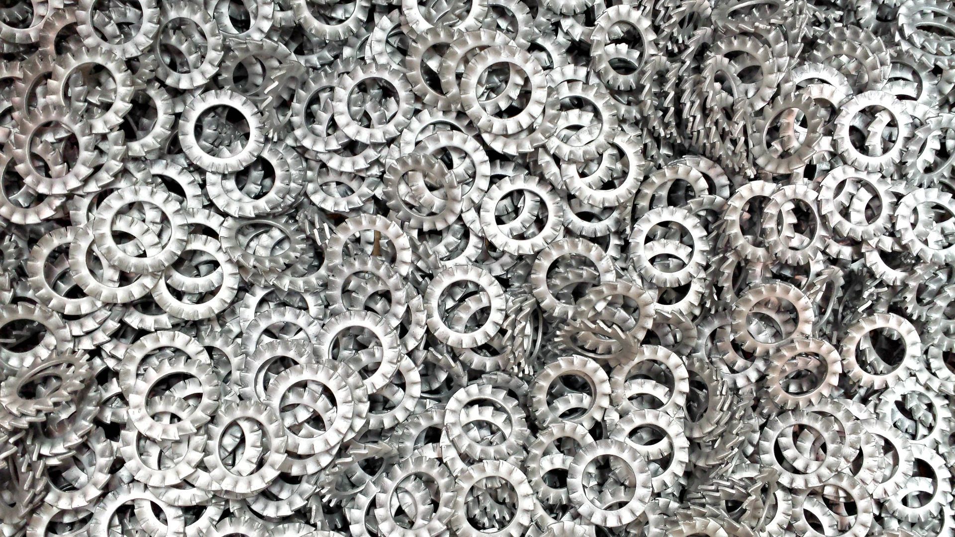 Un mucchio di rondelle di metallo argentato riempie la cornice.