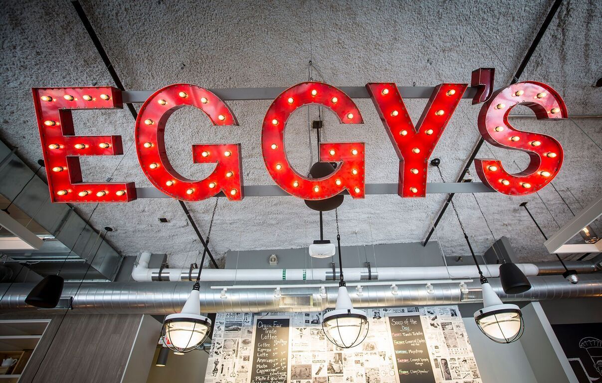 A red sign that says eggy 's hangs from the ceiling of a restaurant
