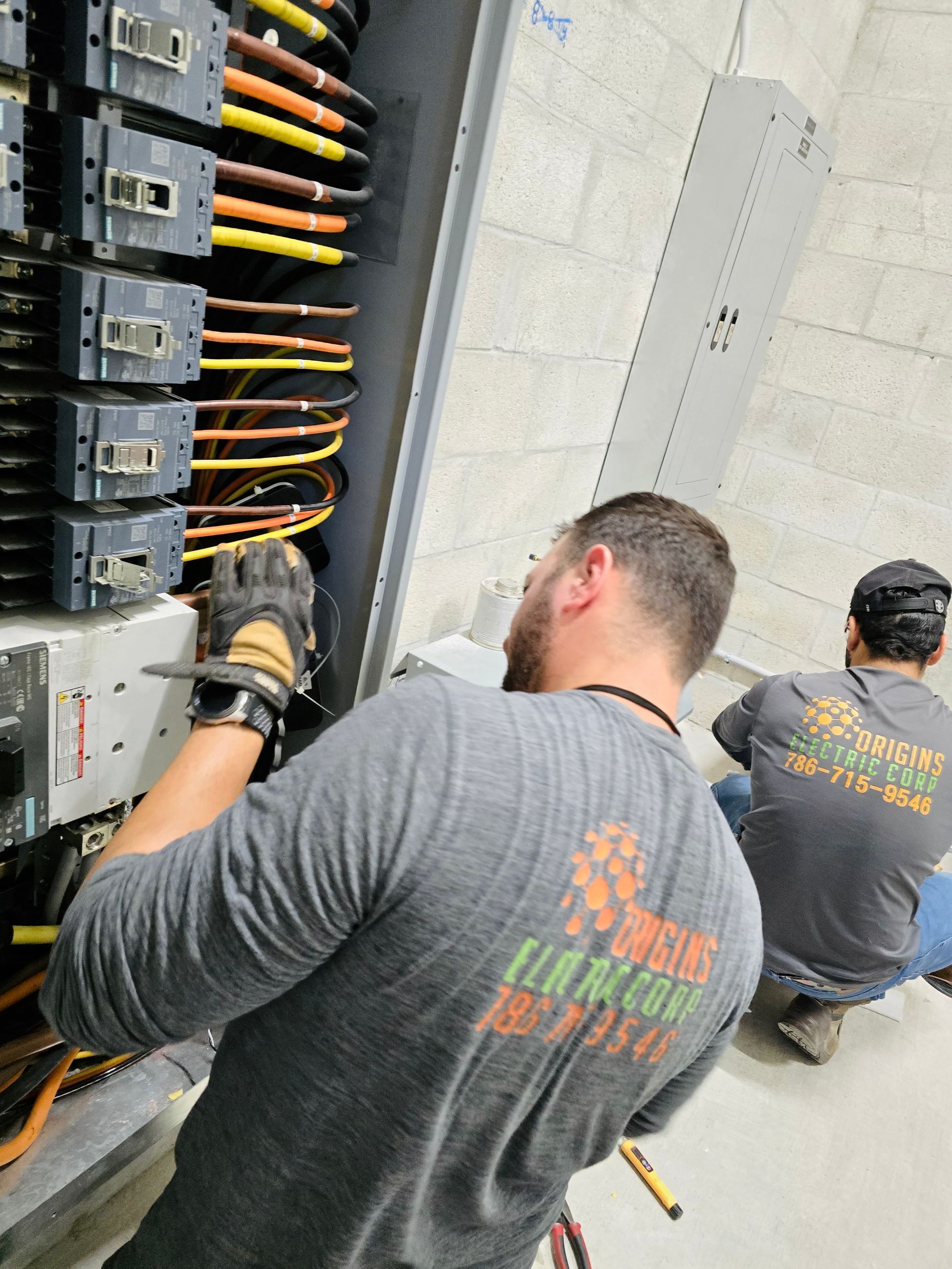Open electrical breaker panel with many wires and circuit breakers neatly arranged