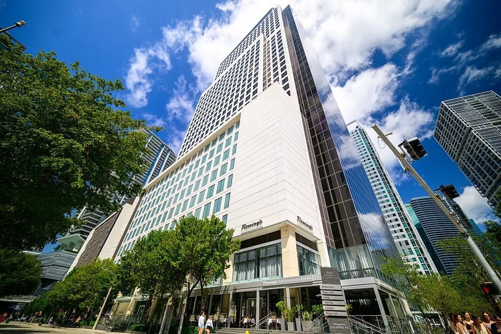 A view of the expansive, modern terminal at Hamad International Airport, featuring a central sculpture under a high ceiling.