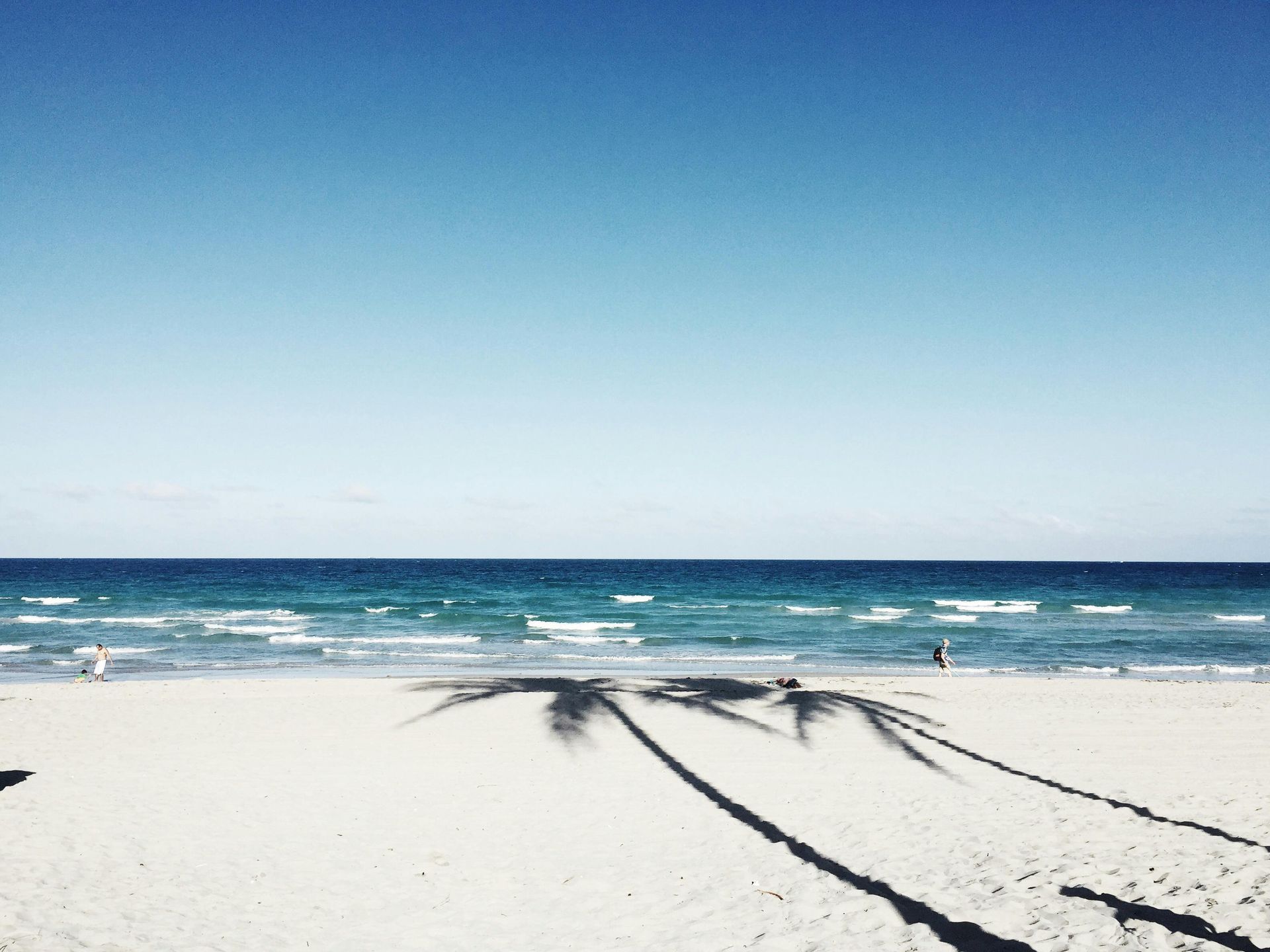 A modern two-story home with wood accents and a covered carport, set in a snowy landscape at twilight.