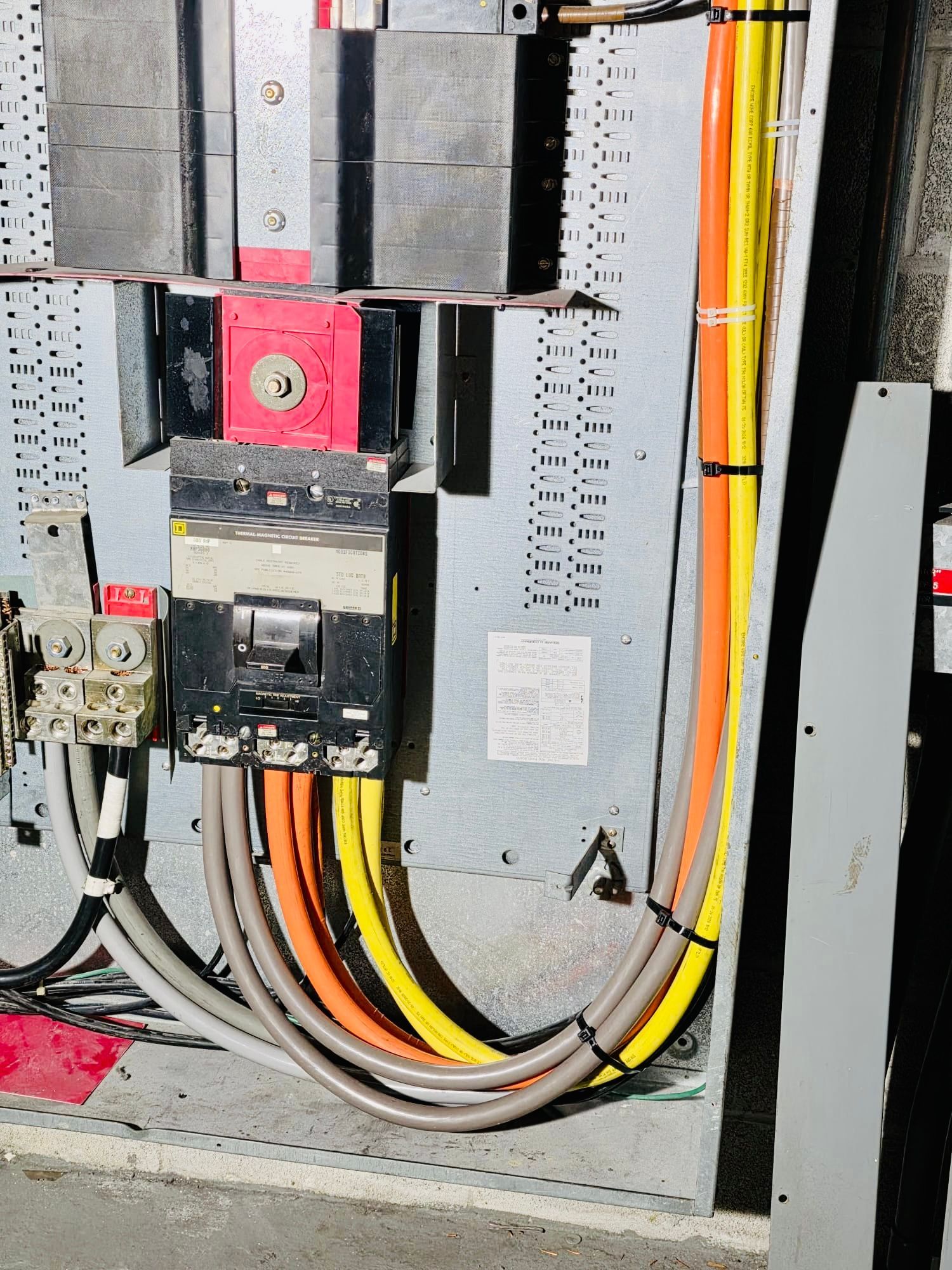 An open electrical control box featuring a circuit breaker, a logic controller board, terminal blocks, and colored wiring.