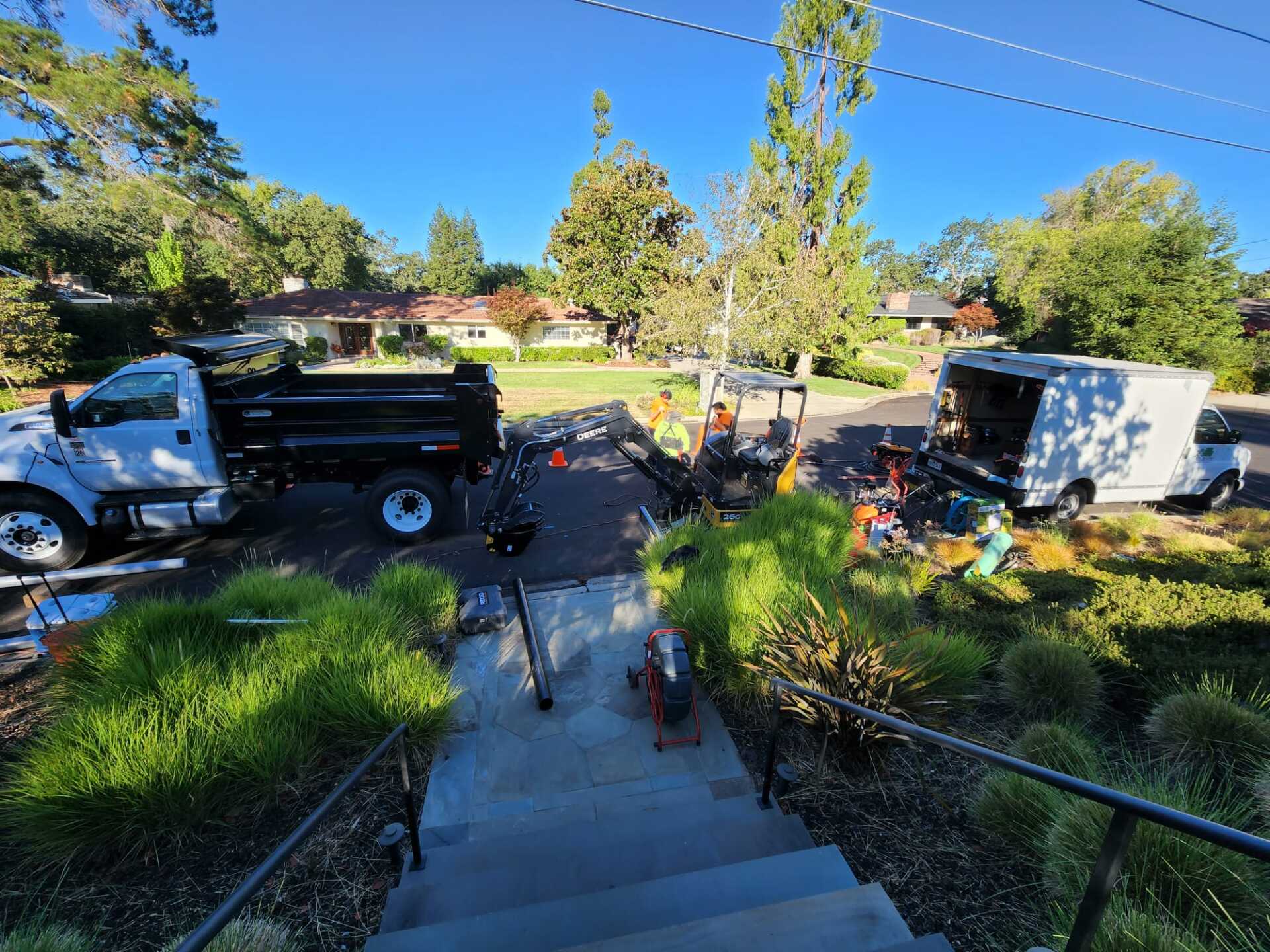A dump truck is parked on the side of the road next to a set of stairs.