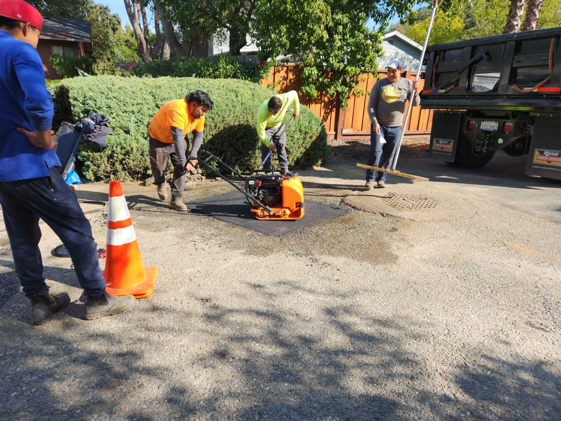 A group of construction workers are working on a driveway.