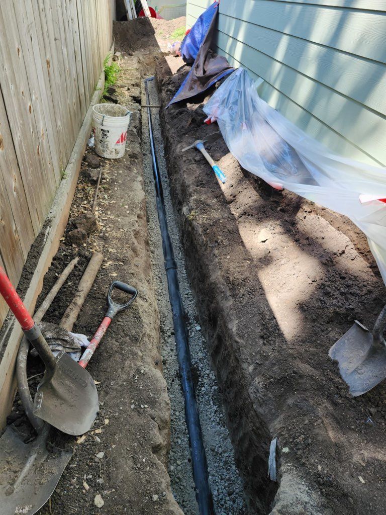 A couple of shovels sitting on top of a pile of dirt next to a fence.