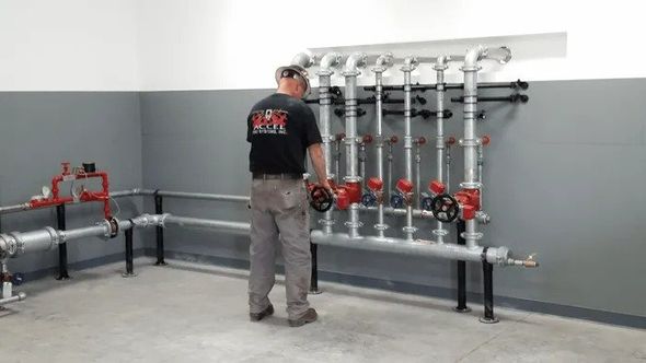 A man holding the valve — Anchorage, AK — Accel Fire Systems, Inc. A man holding the valve — Anchorage, AK — Accel Fire Systems, Inc.