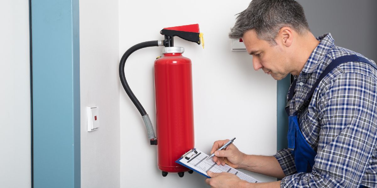 A guy checking the fire extinguisher — Anchorage, AK — Accel Fire Systems, Inc.