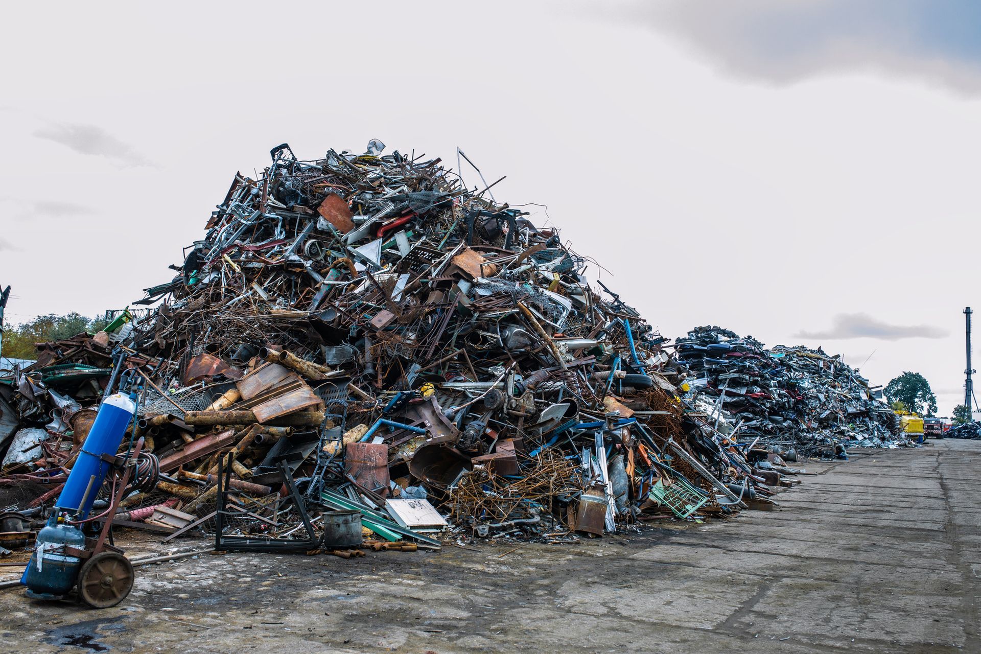 Piles of metal scrap tower under open sky, showcasing quick and reliable metal recycling. Piles of metal scrap tower under open sky, showcasing quick and reliable metal recycling.