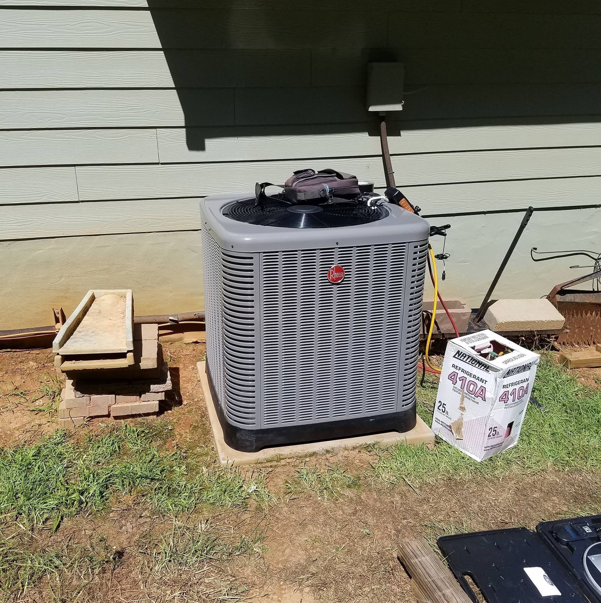 An air conditioner is sitting on the side of a house.
