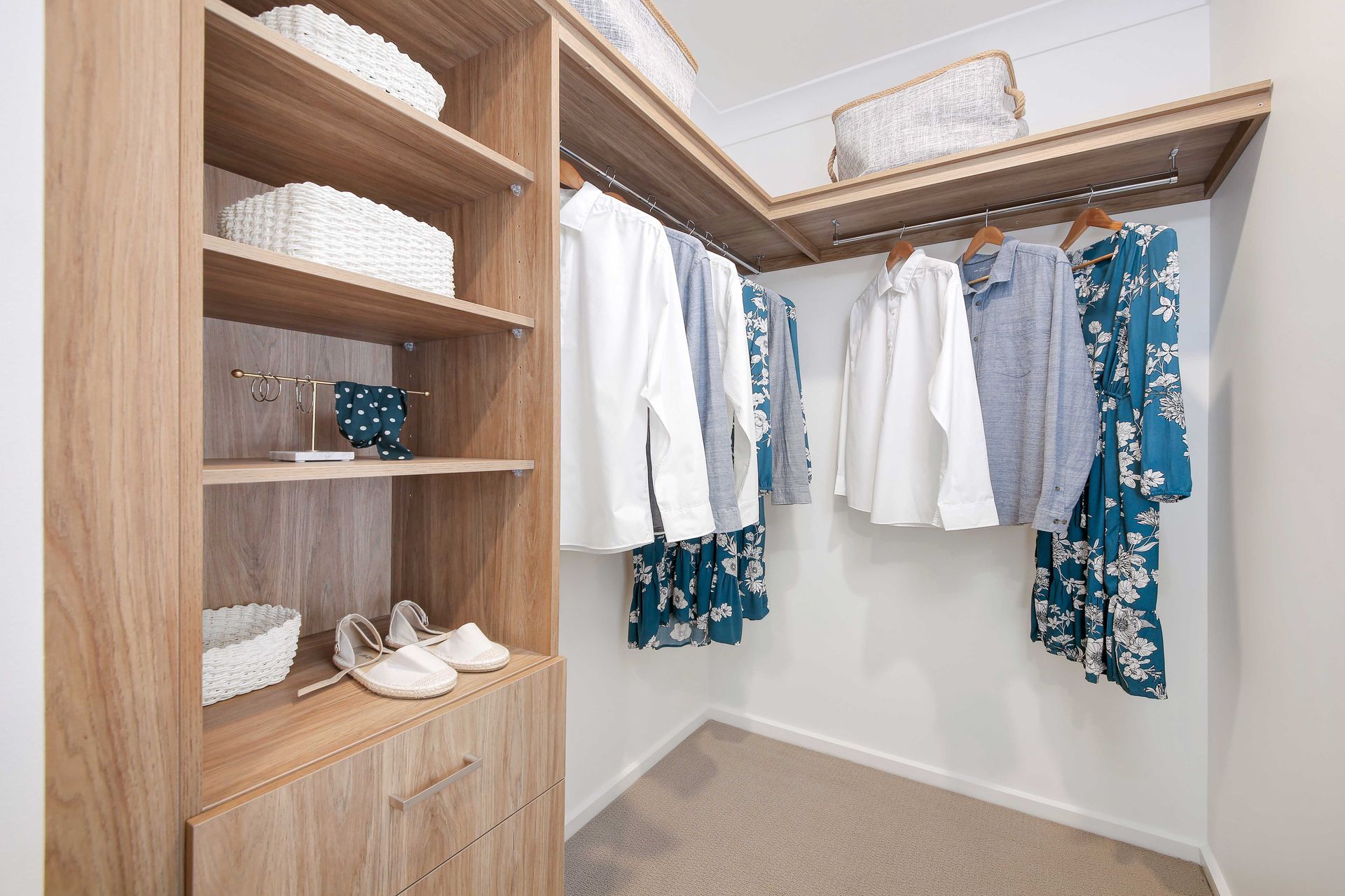Crest 24 home design - A walk in closet with clothes hanging on wood racks and shelves.