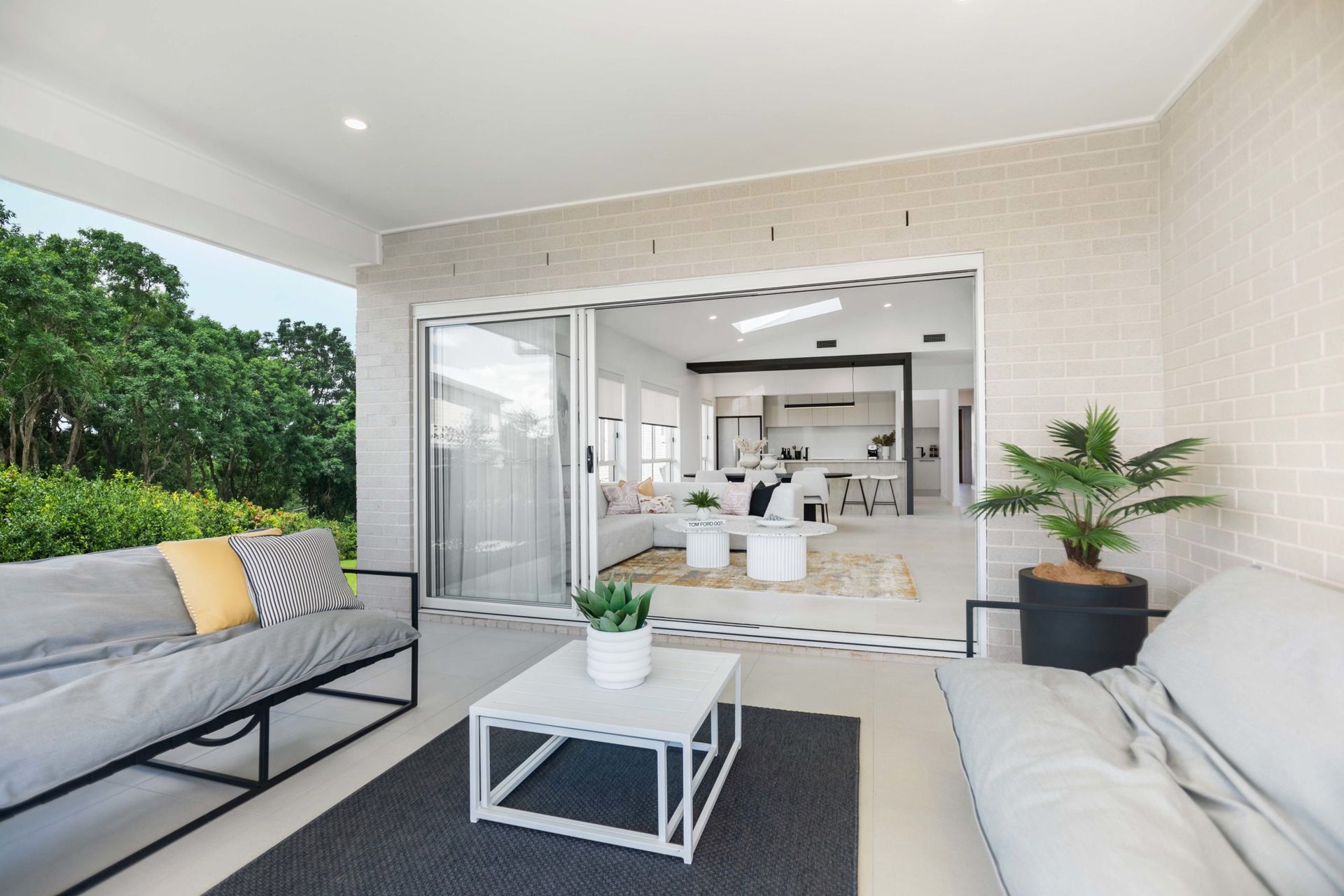 Grove 24 home design - A living room with a couch, table, and potted plant.