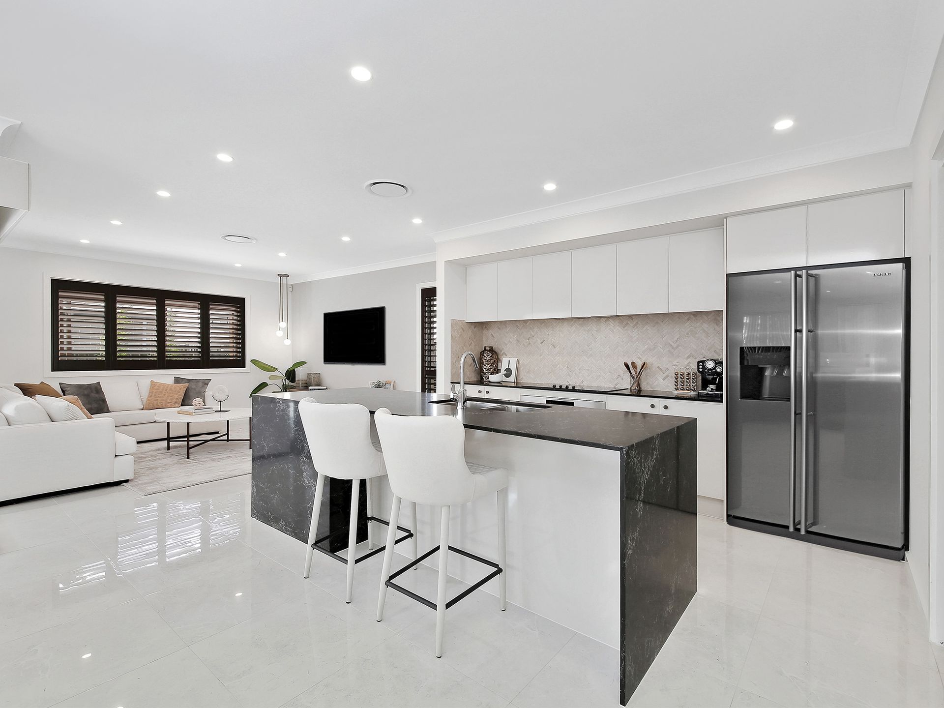 Riviera 26 home design - A kitchen with a stainless steel refrigerator and a marble counter top.
