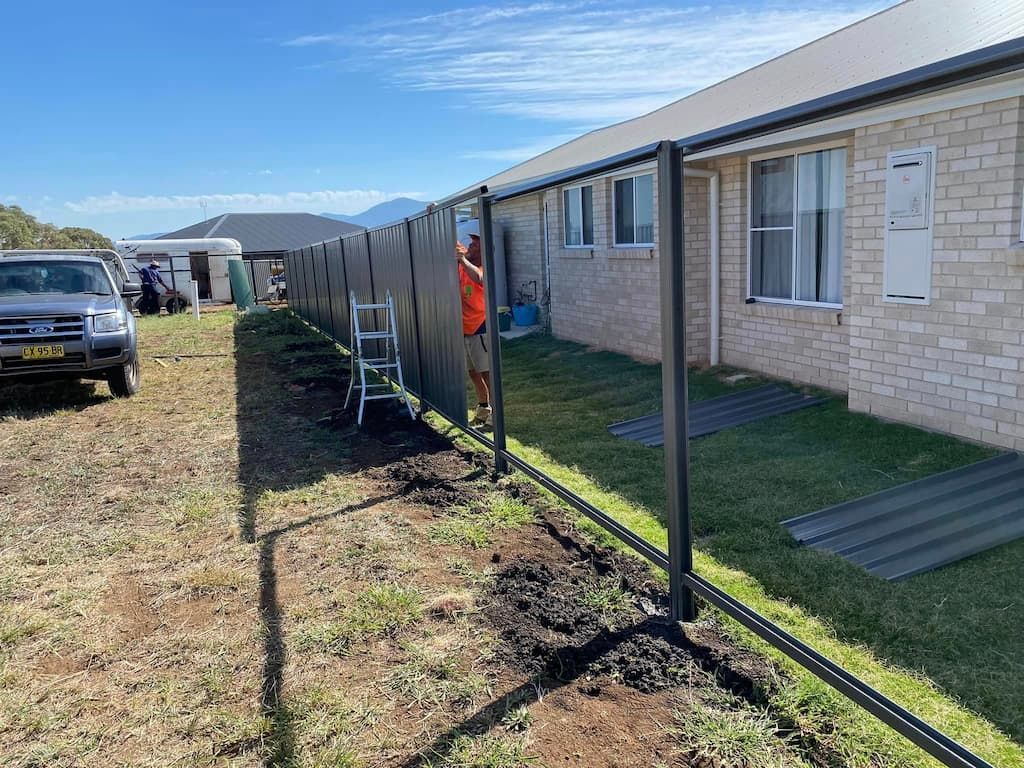 A Fence Is Being Built in Front of A Brick House — DW Fencing Tamworth in Taminda, NSW