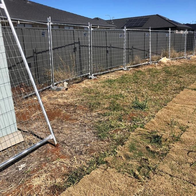 A Fence Is Surrounding a Grassy Field in Front of A House — DW Fencing Tamworth in Taminda, NSW