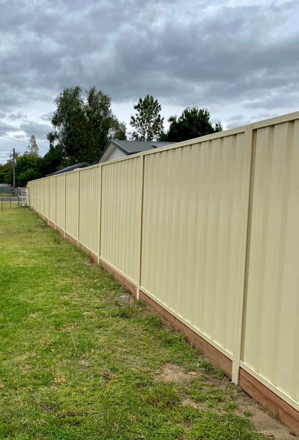 A Long White Fence Surrounds A Lush Green Field — DW Fencing Tamworth in Taminda, NSW