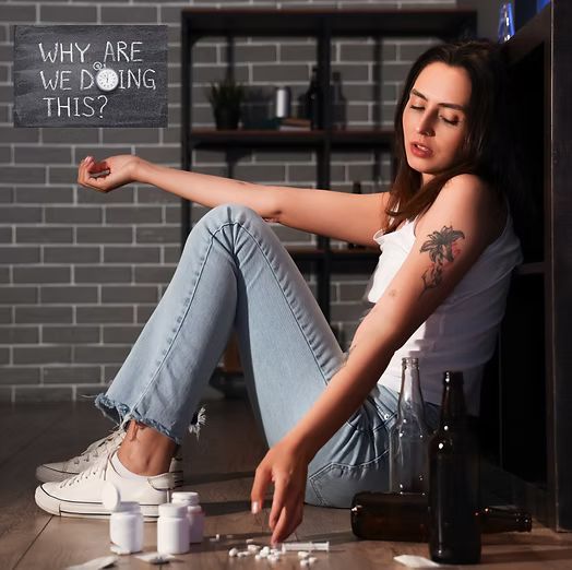Woman slumped against wall, surrounded by pills and alcohol bottles. Question 