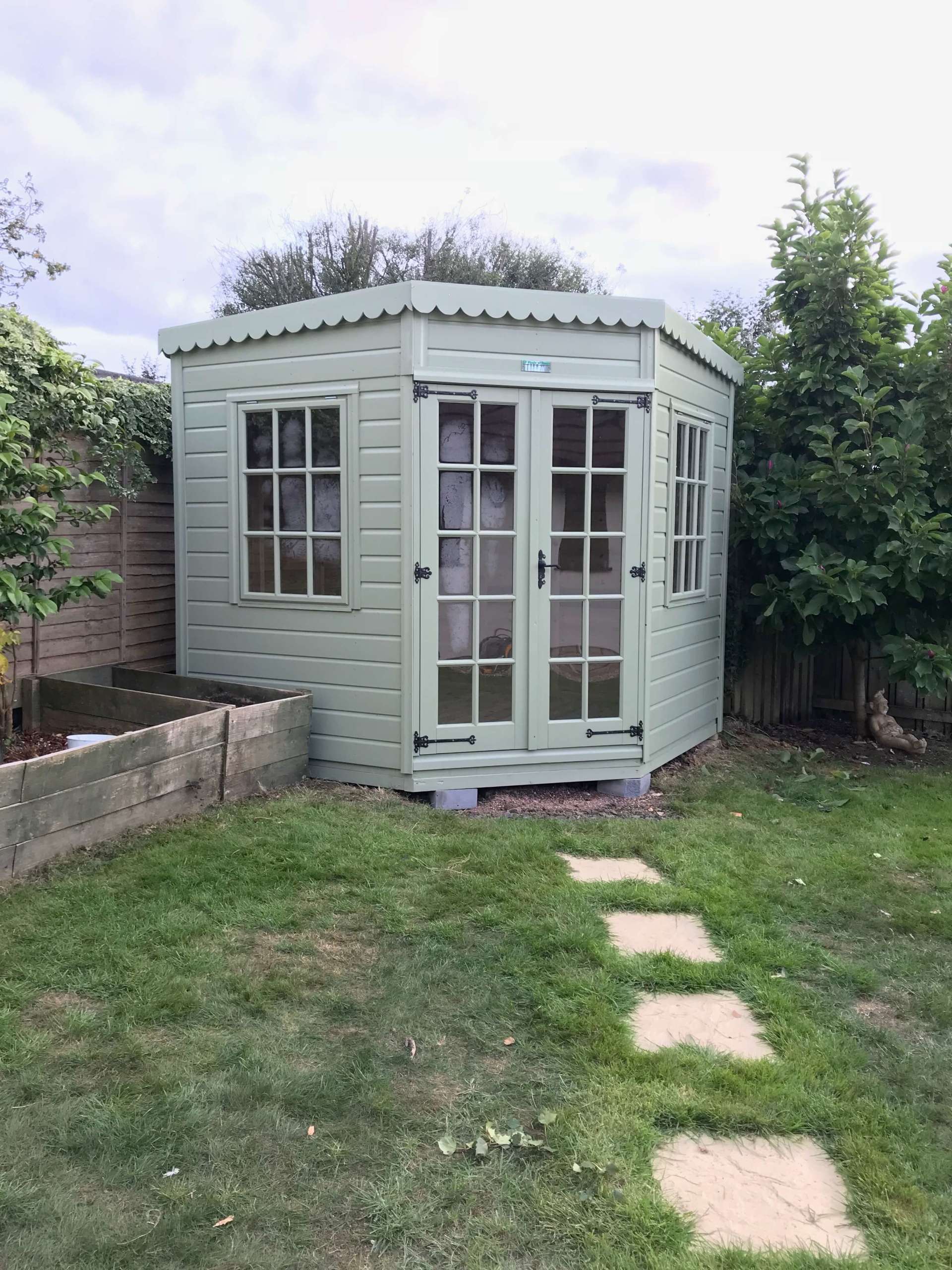 Devon Corner Summer House Shed painted and fitted to the corner of a garden