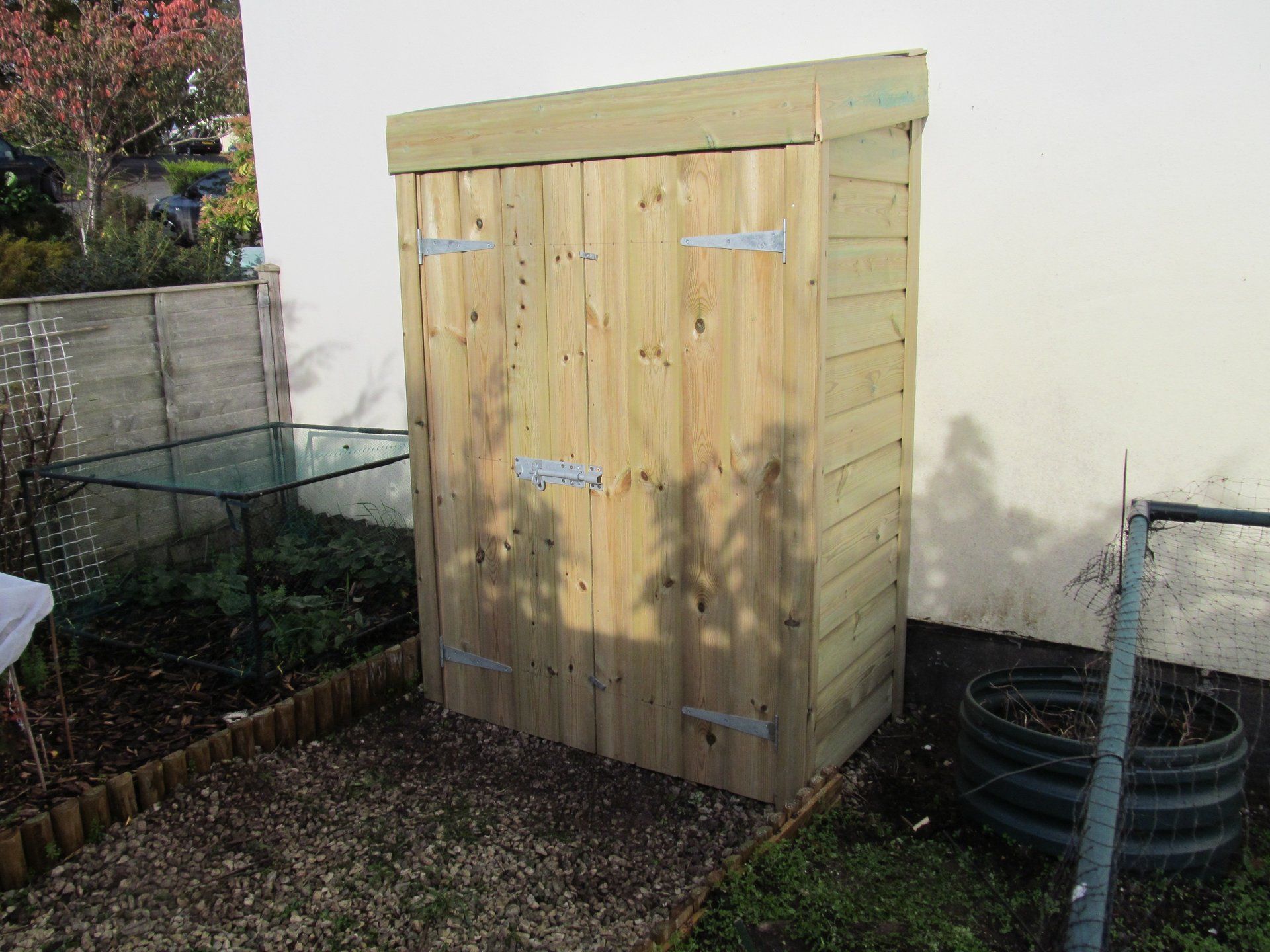 Garden storage shed with sloping roof against house wall