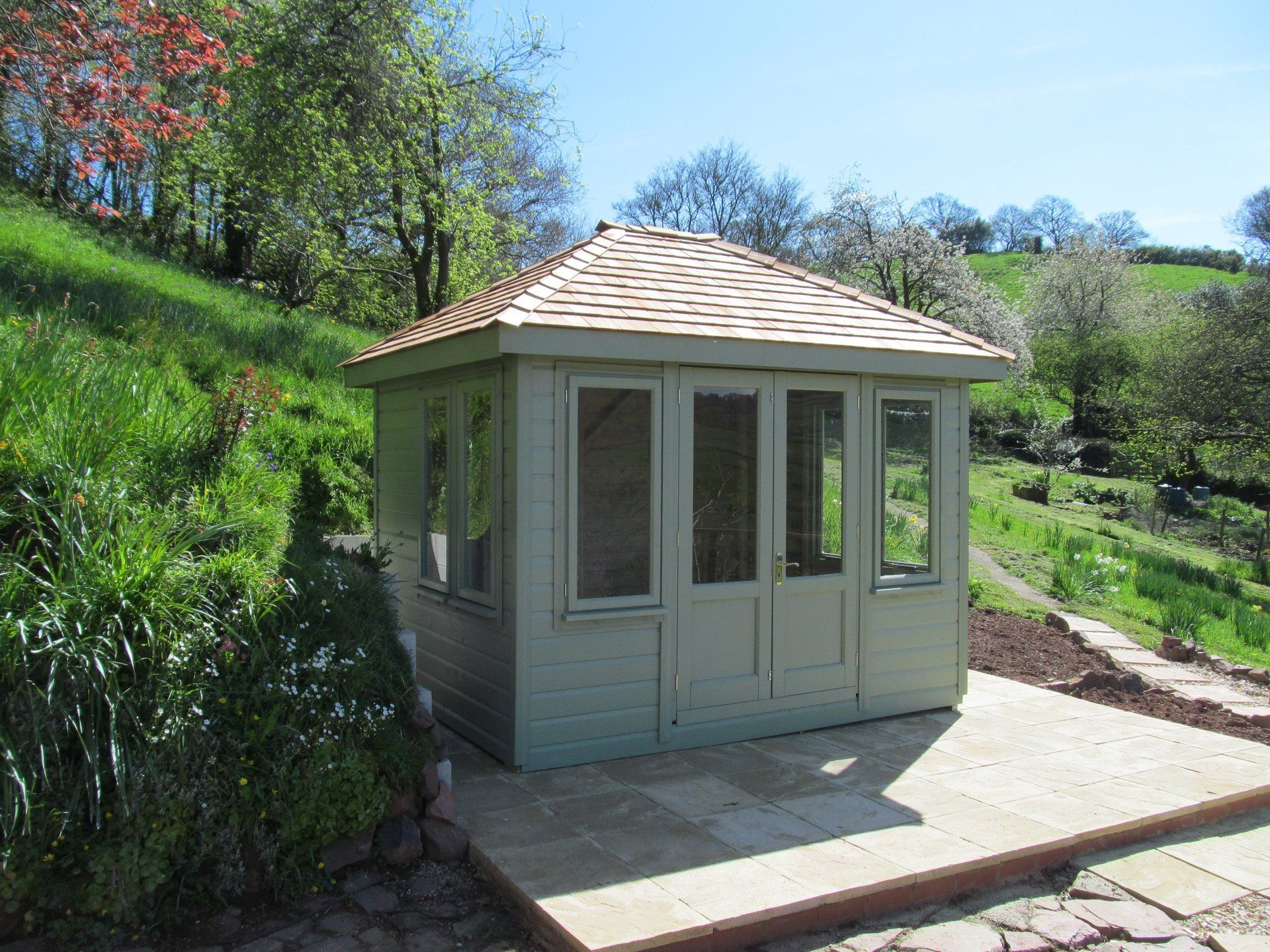 The hip roof summerhouse painted with decking area around