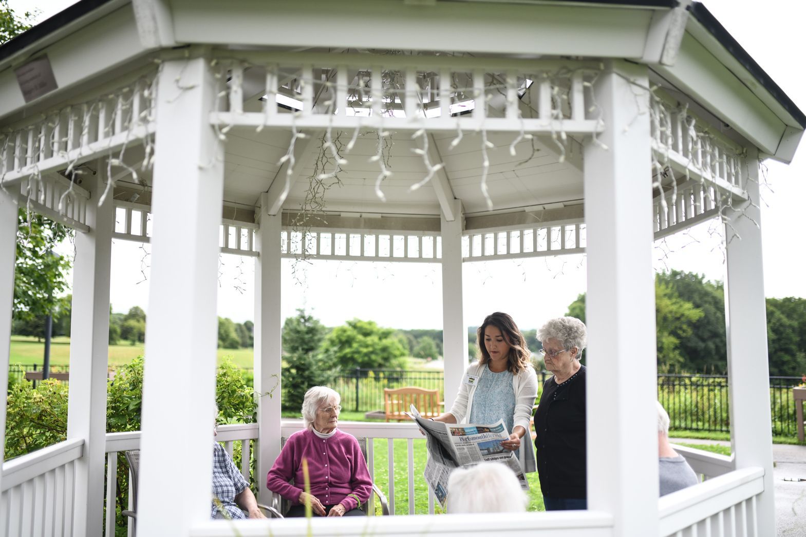 Residents and visitors gathering under the white gazebo at Watson Assisted Living