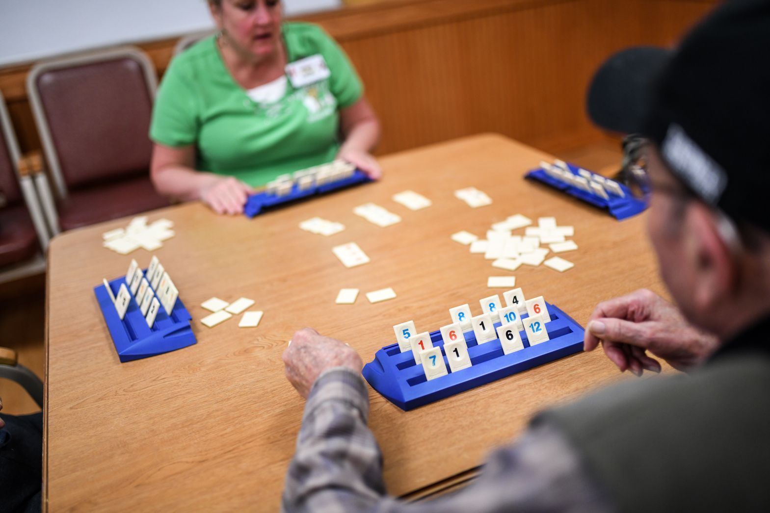 Residents playing a tabletop game together at Watson Assisted Living community room