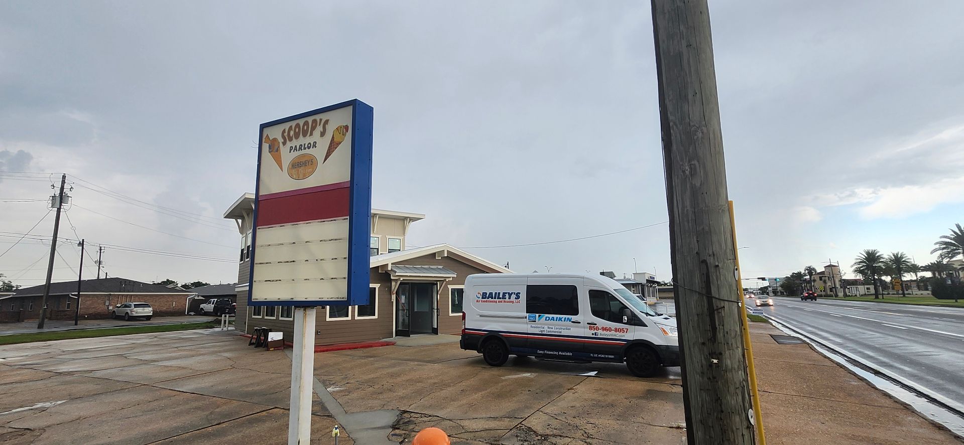A white van is parked in front of a sign that says ' ambulance ' on it.