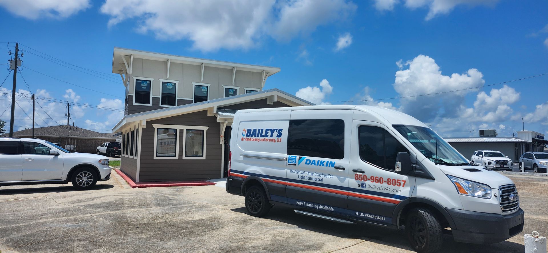 A white van is parked in front of a building.