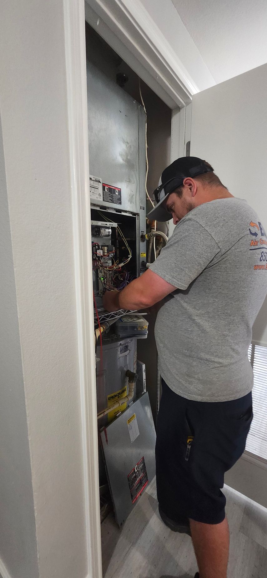 A man is working on a heating system in a room.