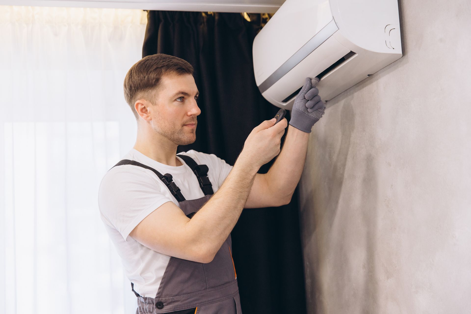 Bailey’s HVAC technician checking frozen AC coils with visible ice buildup signaling a malfunction.