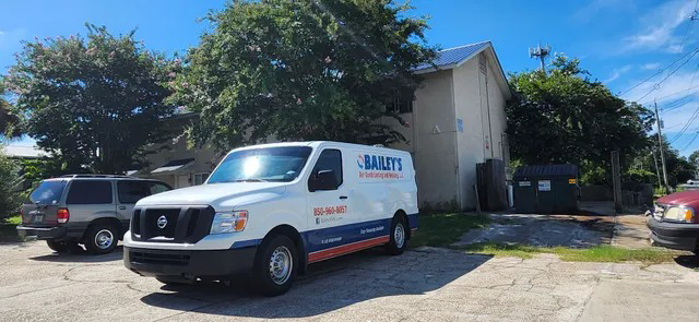 A white van is parked in front of a building.