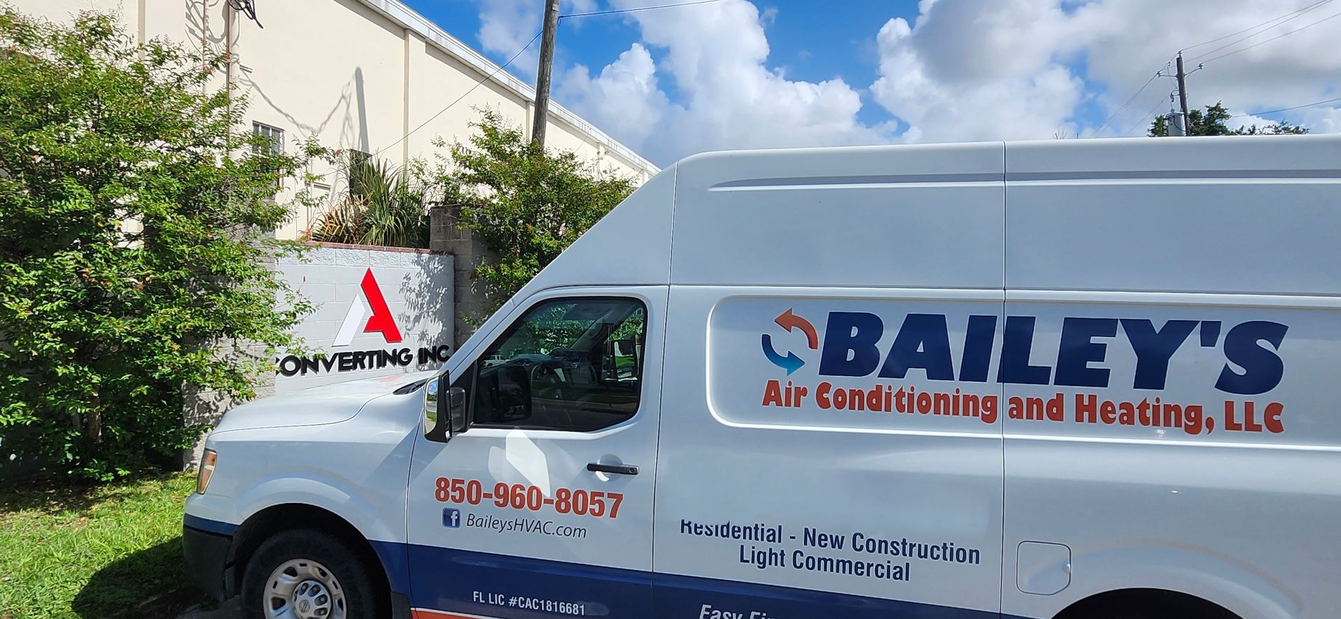 A bailey 's air conditioning and heating van is parked in front of a building.
