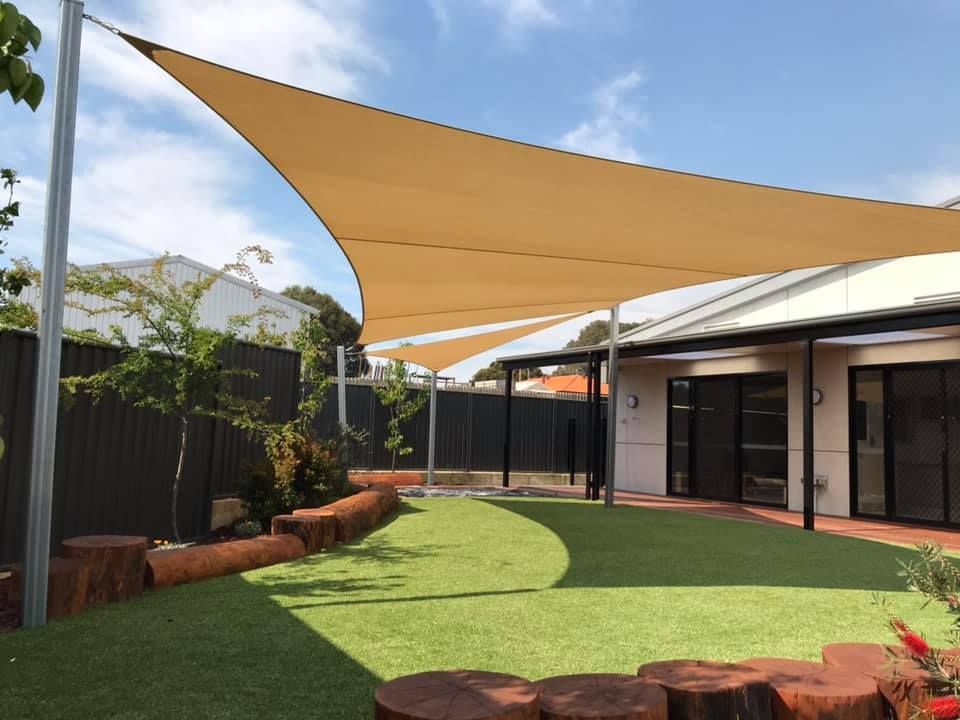 A house with a large shade sail in the backyard
