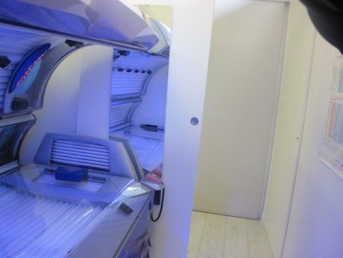 Macchina automatizzata per interni, bianca e blu, con pannello aperto e una piccola porta accanto.