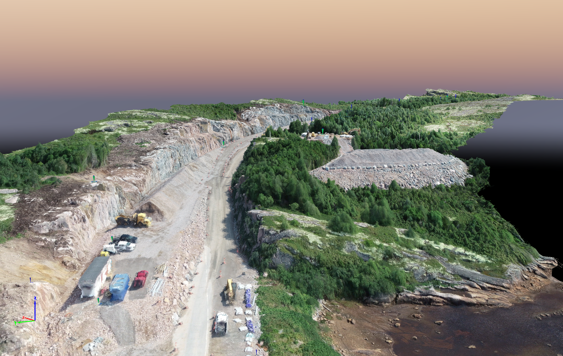 Rendu aérien 3D d'une carrière côtière montrant un chemin de terre, des équipements industriels et une forêt adjacente près de l'eau.