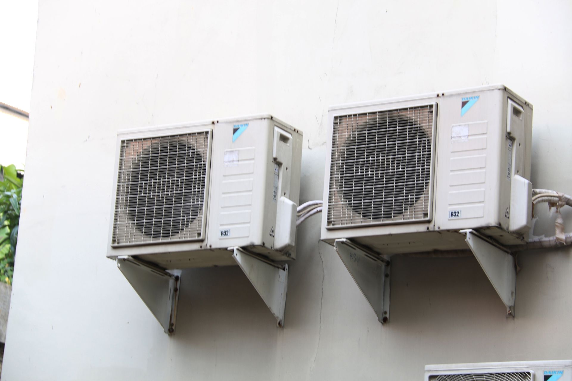 Two air conditioners are mounted on the side of a building.