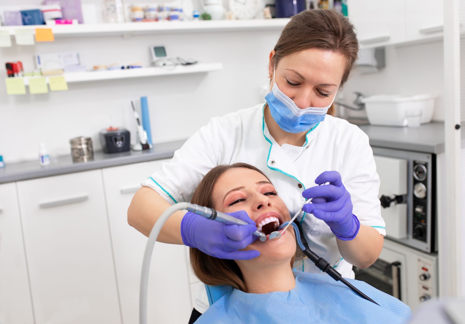 A woman is getting her teeth examined by a dentist in a dental office.