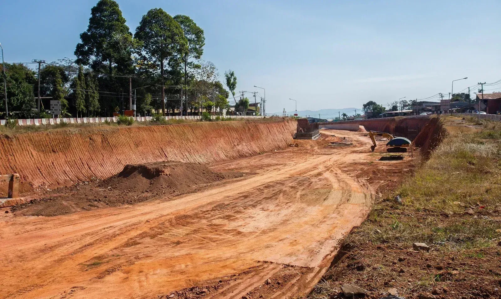 A dirt road is being built in the middle of a field.