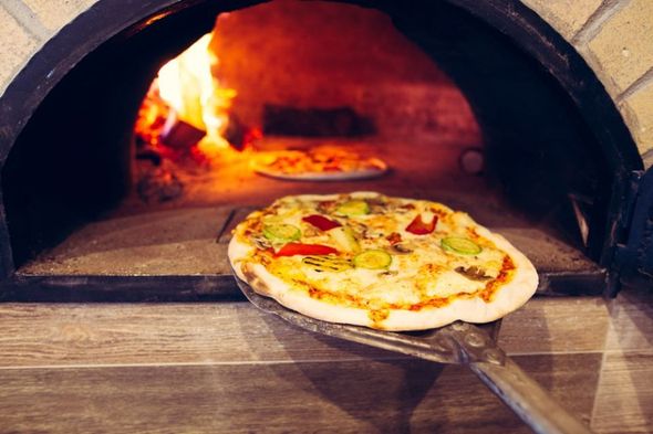 Cottura pizza in forno a legna della pizzeria sul mare a Bari