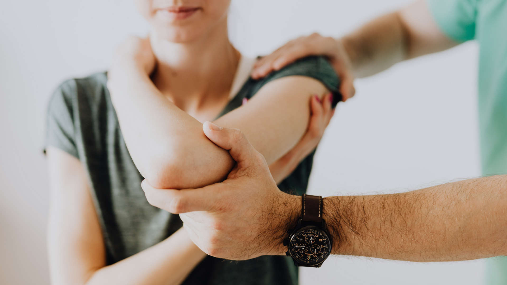 A man is stretching a woman 's elbow.