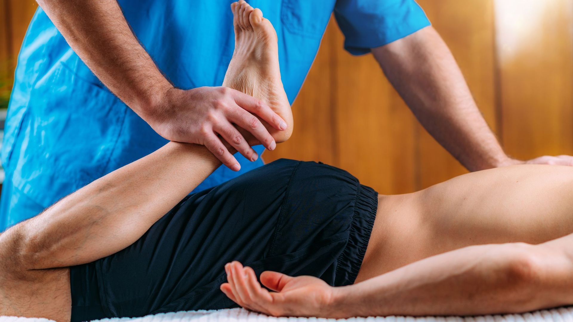 A man is laying on a table getting a massage from a doctor.