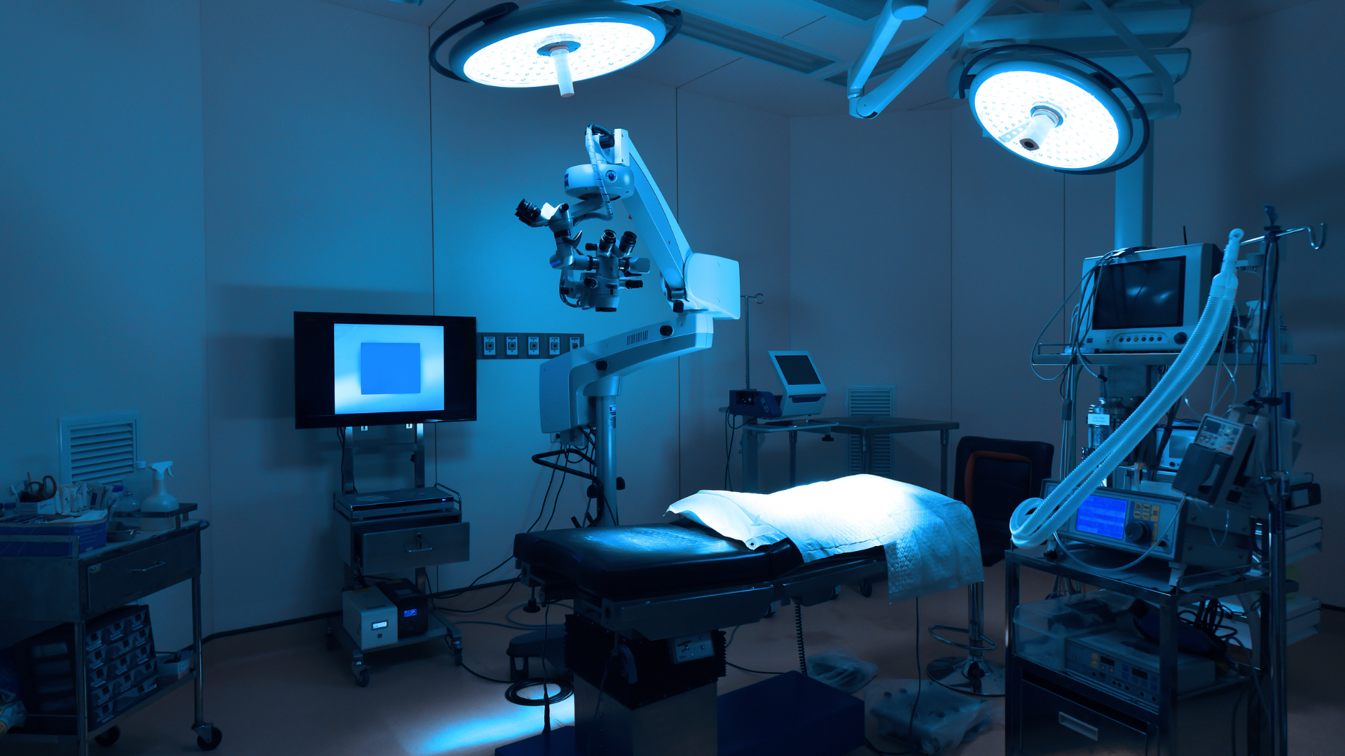 An operating room in a hospital with a bed and a microscope.