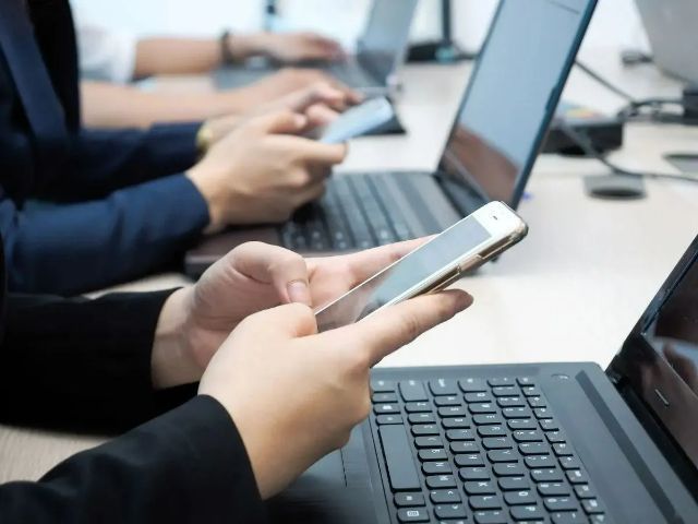 office-workers-at-desk-with-laptops=and-cellular-phones