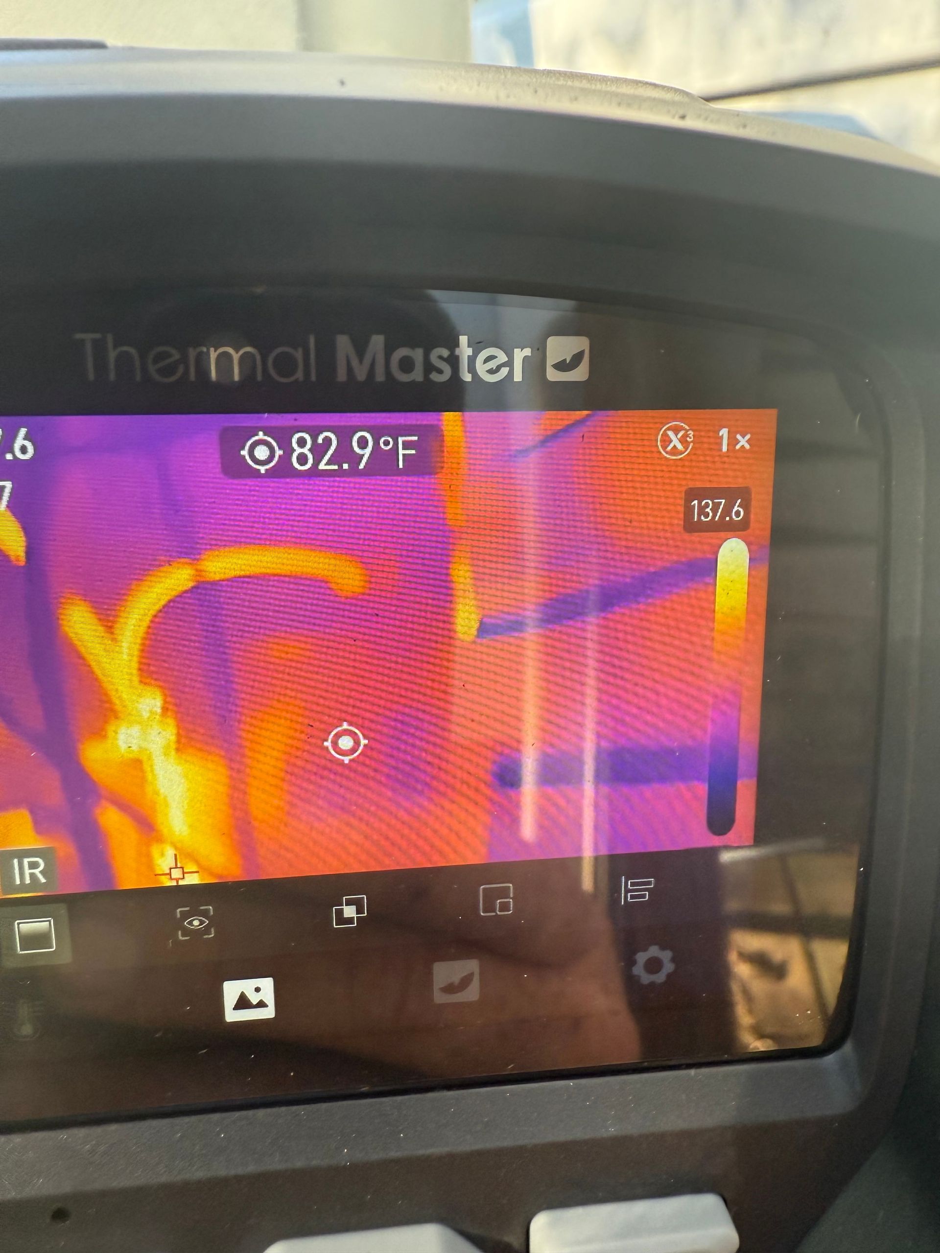 A thermal imaging camera display showing a heat map with yellow and orange areas indicating warmer temperatures.