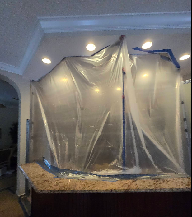 A dirty closet with a jacket hanging on the door