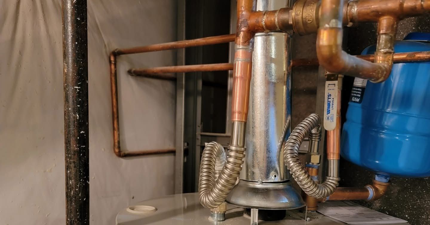 Copper pipes and blue tank, possibly a water heater or plumbing system.