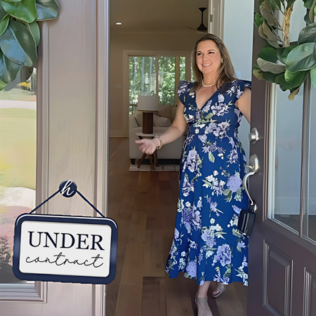 Woman in blue floral dress opens the front door of a house with 