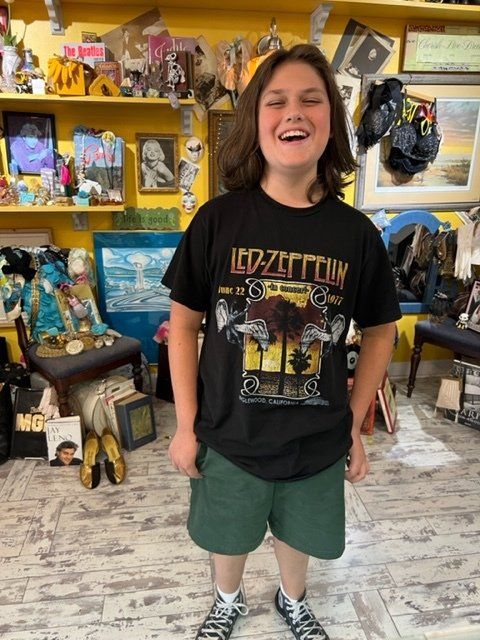 A young boy wearing a black led zeppelin t-shirt